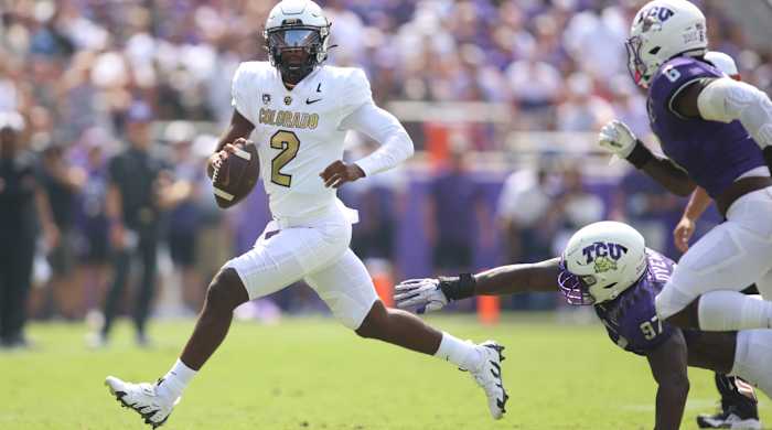 Colorado quarterback Shedeur Sanders eludes TCU defenders during his debut for the Buffaloes. He wore his father’s famous cleats, the Nike Diamond Turf 96, for the game.